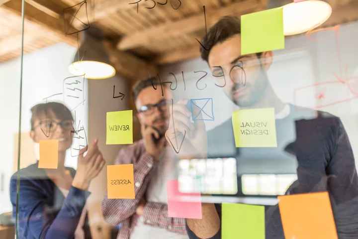 Employees working on ideas on a whiteboard