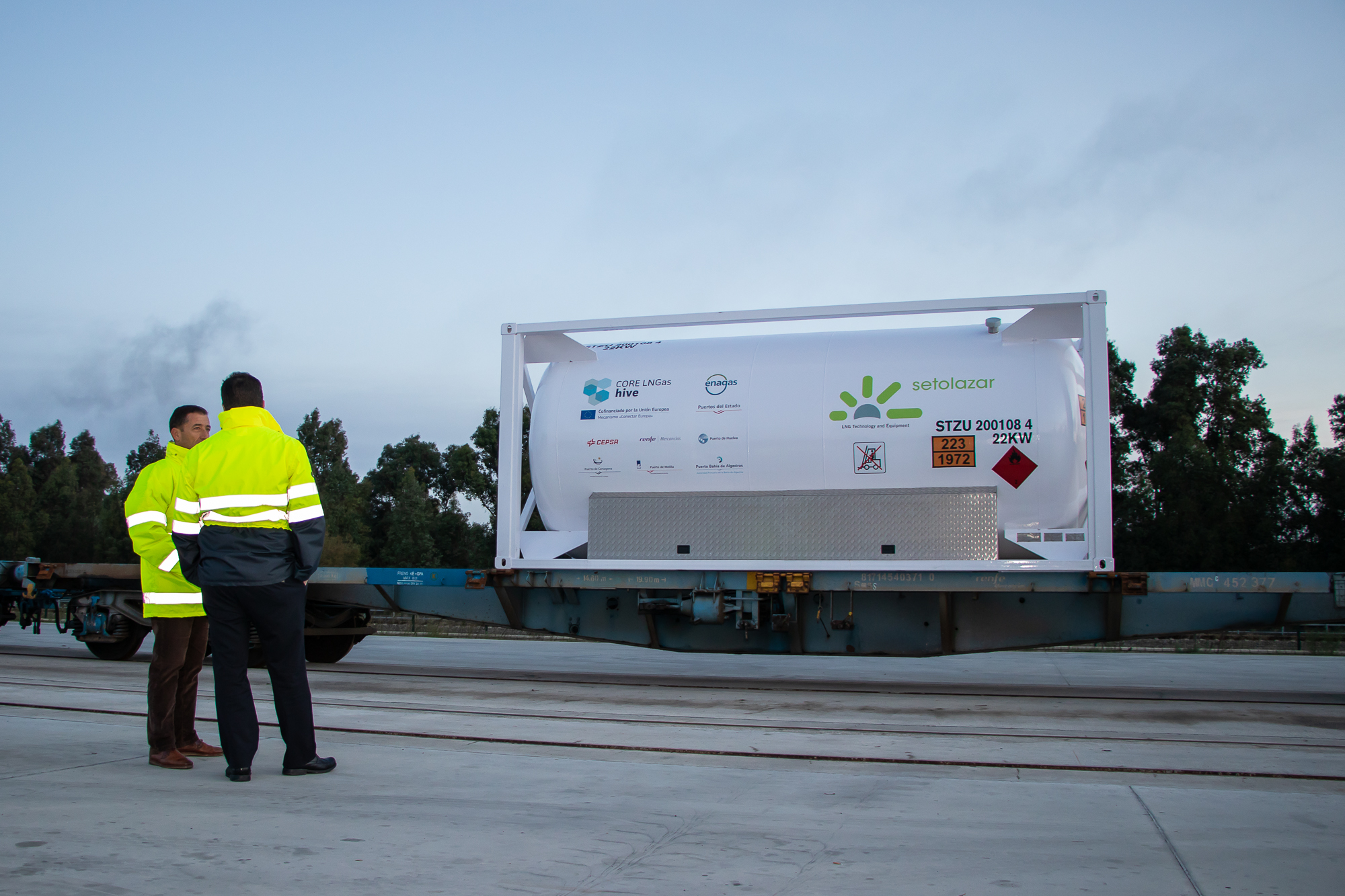 Two people talking in front of a poster about the CORE LNGas hive project