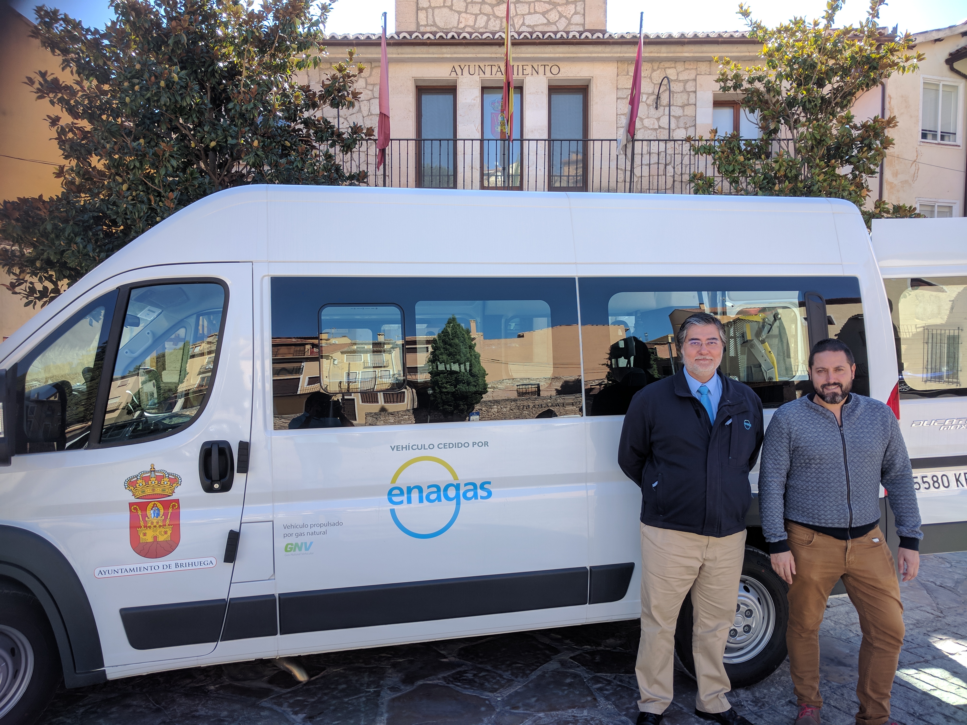 Dos personas posando con una furgoneta propulsada por GNL con el logo de Enagás