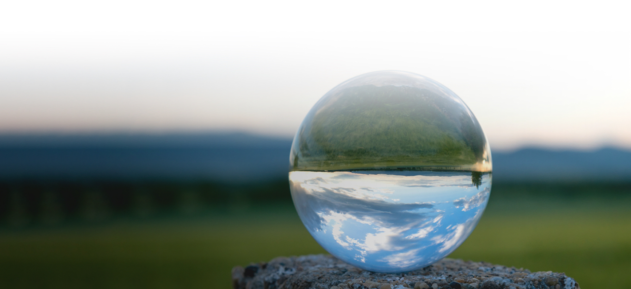 Gota transparente con paisaje verde reflejado